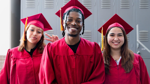 three students at graduation